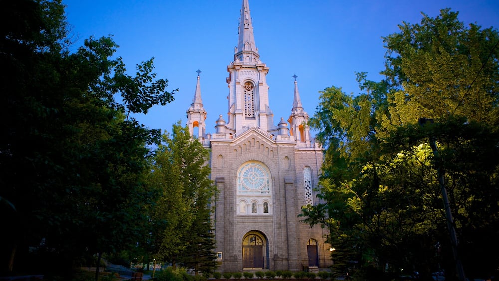 Eine große Kirche mit einem hohen Kirchturm und mehreren Türmen, umgeben von Bäumen.