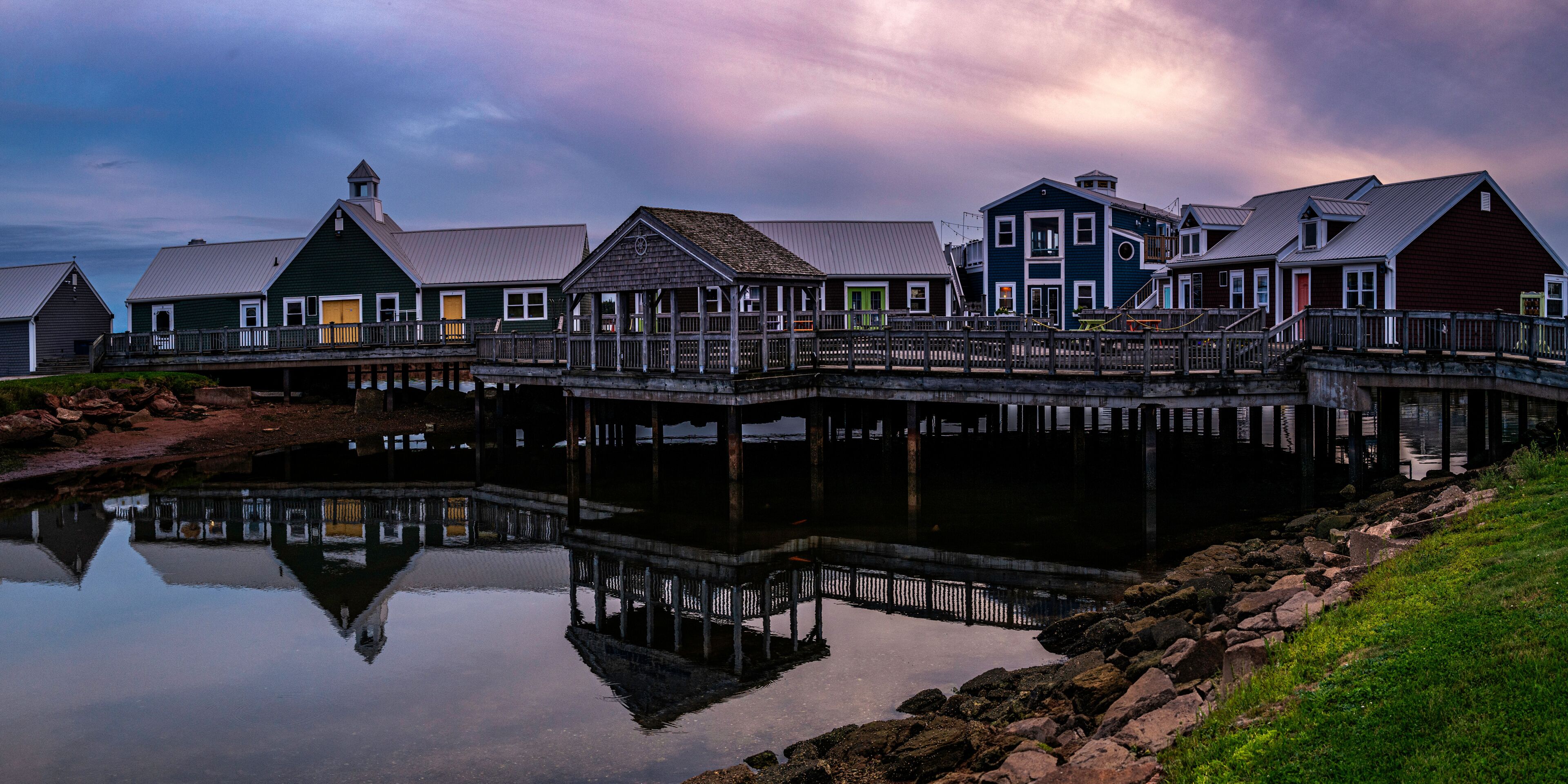 Summerside Harbour Sunset Seascape with rustic cape style houses and stores, and water reflections at twilight hour in Gulf of St Lawrence, Prince Edward Island, Canada