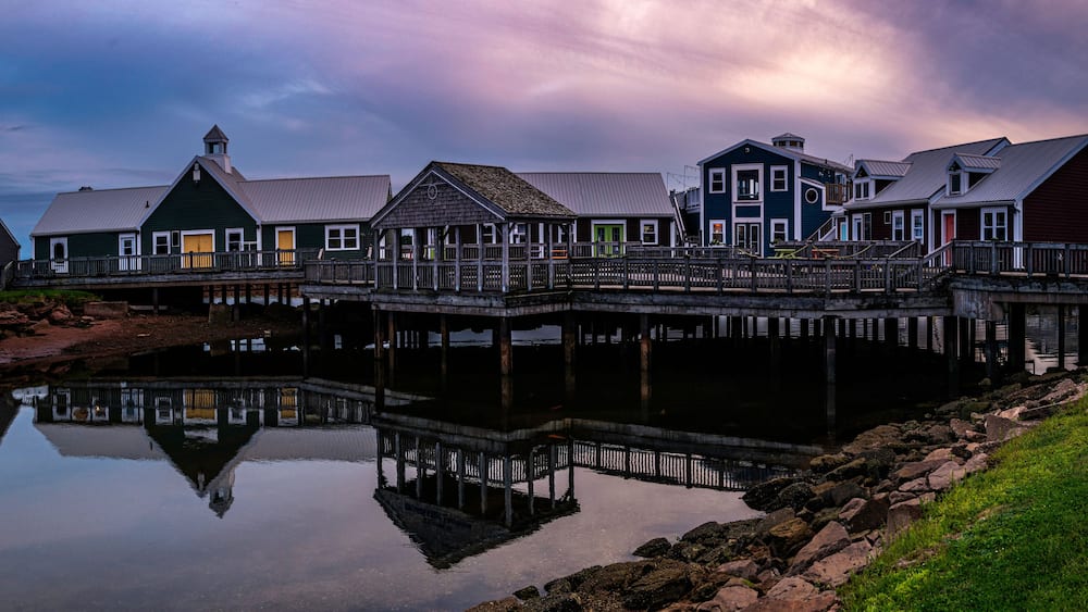 Summerside Harbour Sunset Seascape with rustic cape style houses and stores, and water reflections at twilight hour in Gulf of St Lawrence, Prince Edward Island, Canada