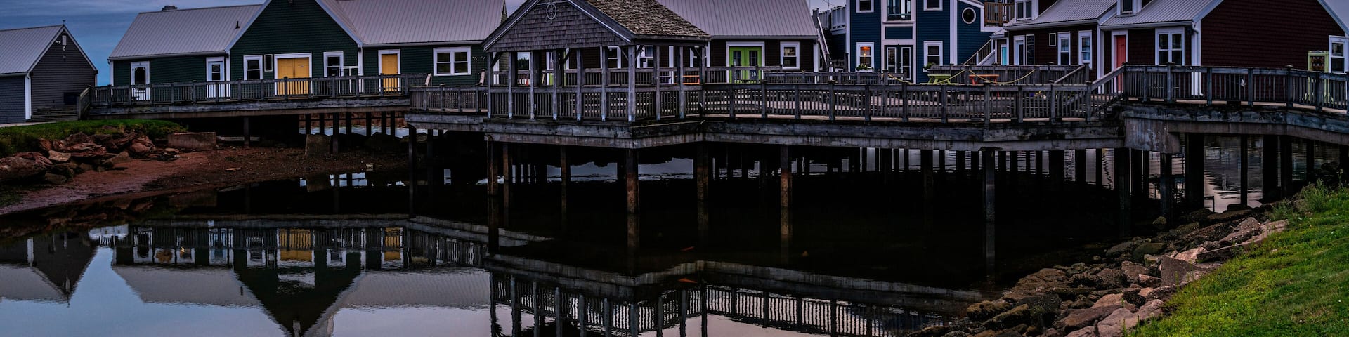 Summerside Harbour Sunset Seascape with rustic cape style houses and stores, and water reflections at twilight hour in Gulf of St Lawrence, Prince Edward Island, Canada