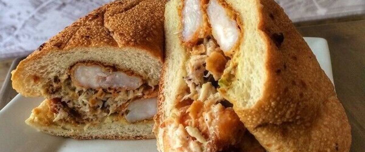 A sandwich cut in half on a white plate.