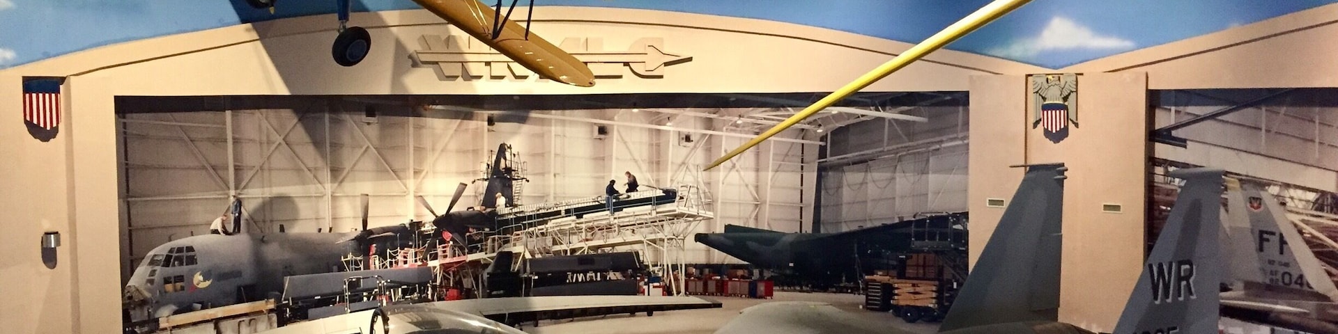 A museum exhibit with various aircraft, including a fighter jet and a biplane.