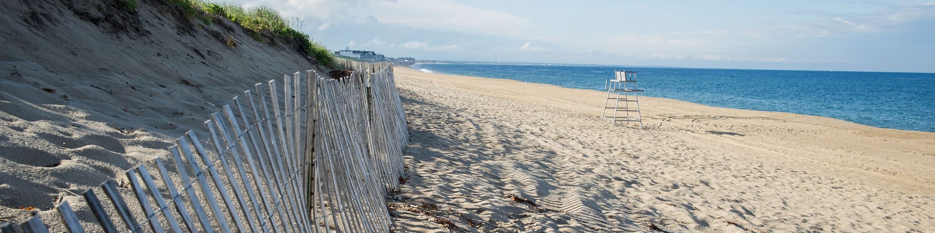DFJN2D Sand dunes with a fence at the beach with the ocean and lifeguard tower in the background