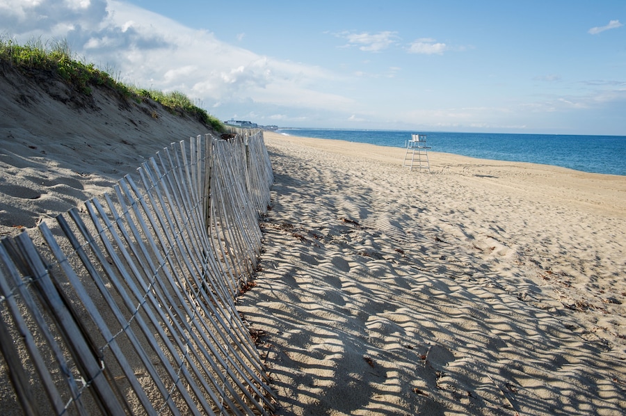 DFJN2D Sand dunes with a fence at the beach with the ocean and lifeguard tower in the background