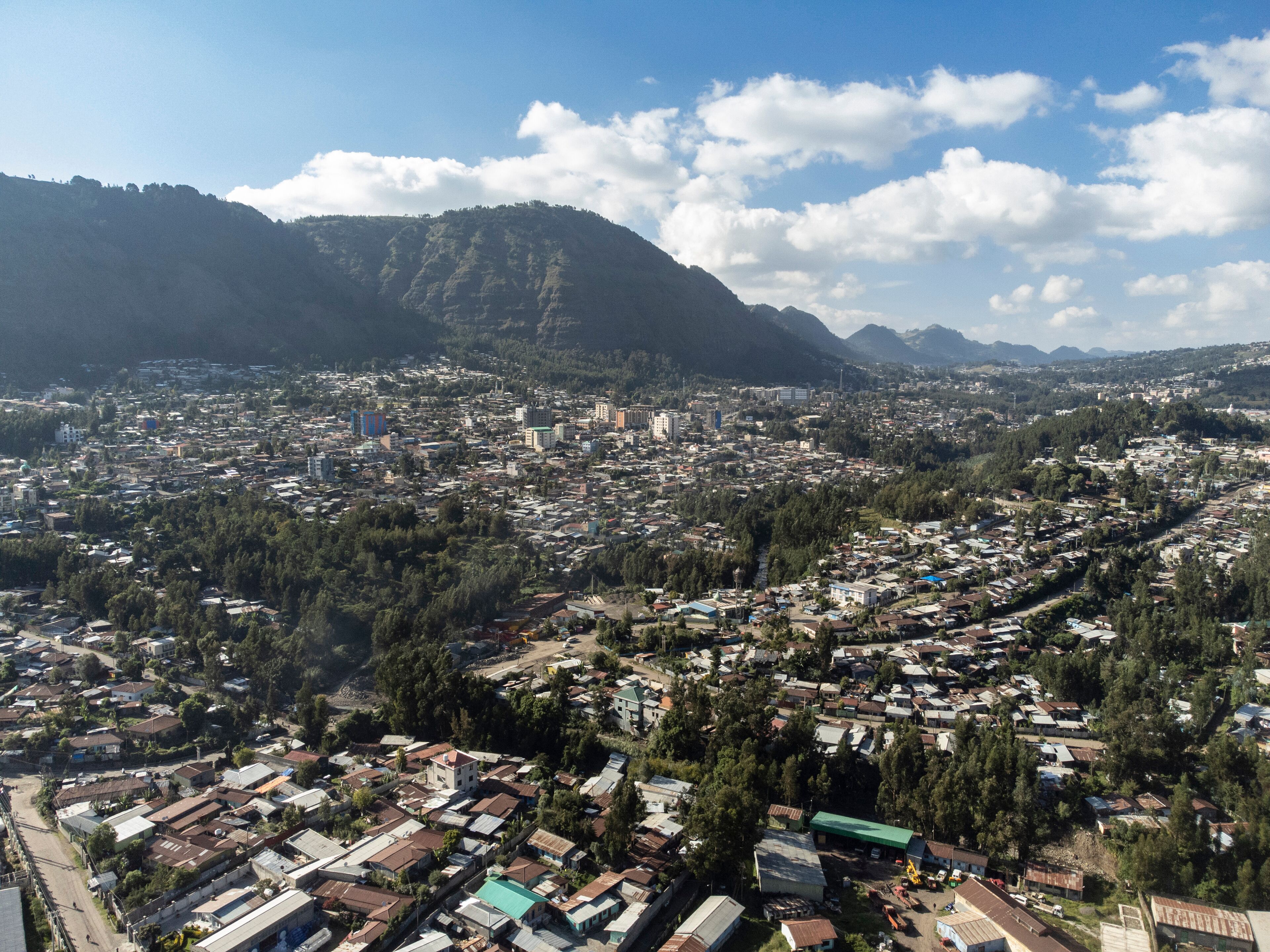 A cityscape with a mountainous backdrop.