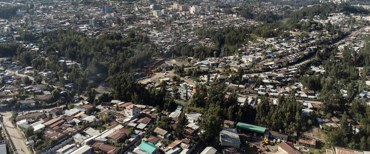 A cityscape with a mountainous backdrop.