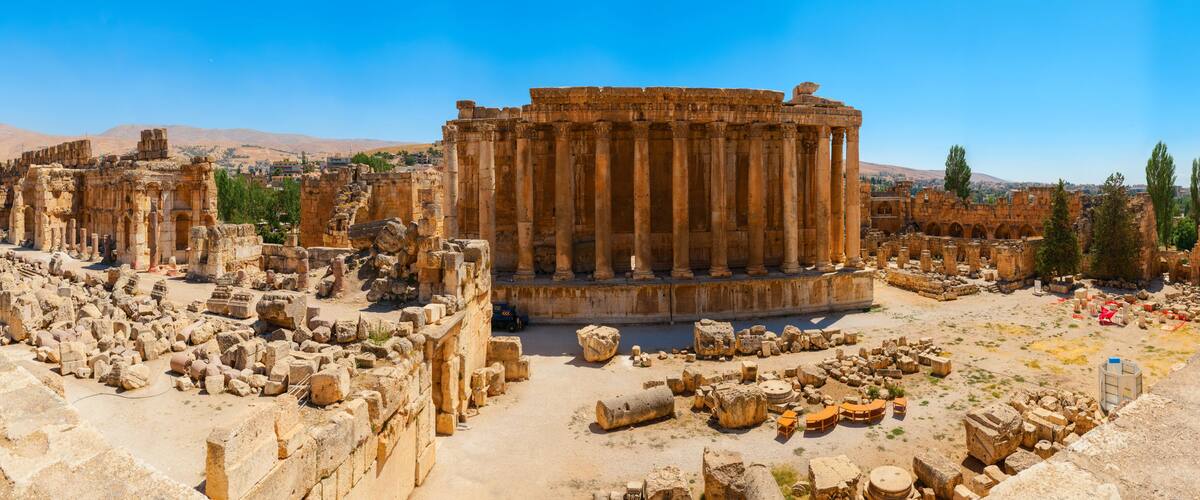 Ancient ruins with columns and scattered stones.