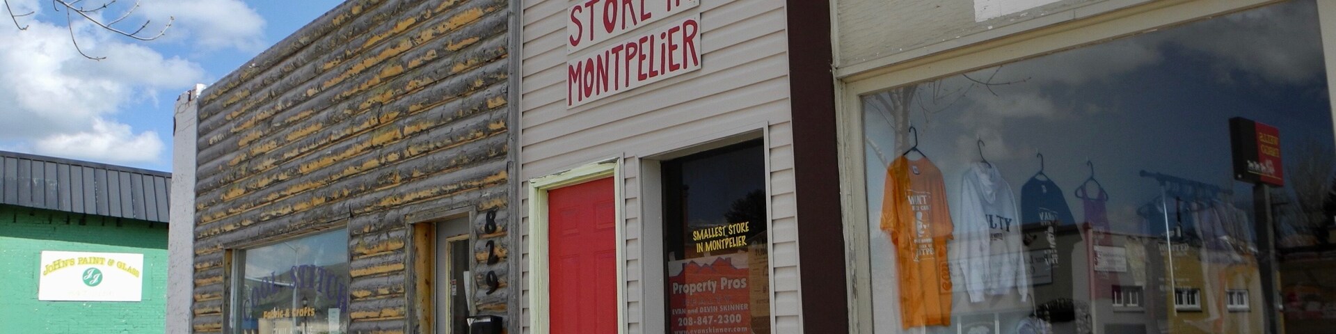 A storefront with a sign stating it's the smallest store in Montpelier.