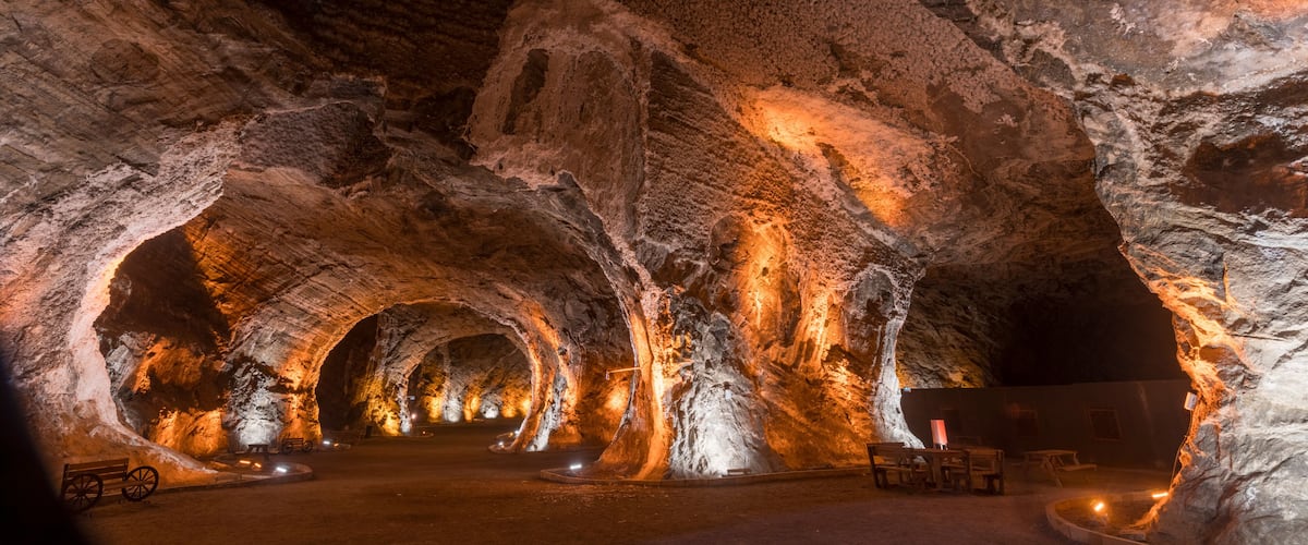 A cave with illuminated rock formations and benches.