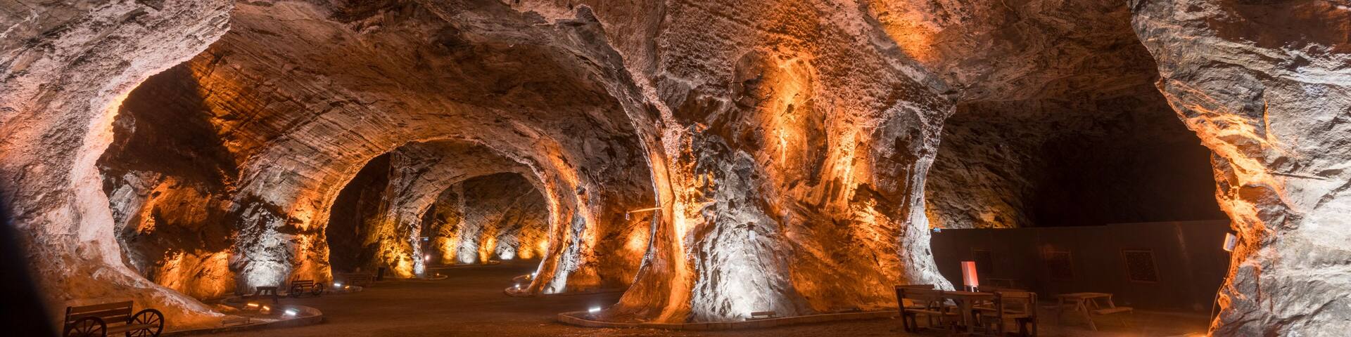 A cave with illuminated rock formations and benches.