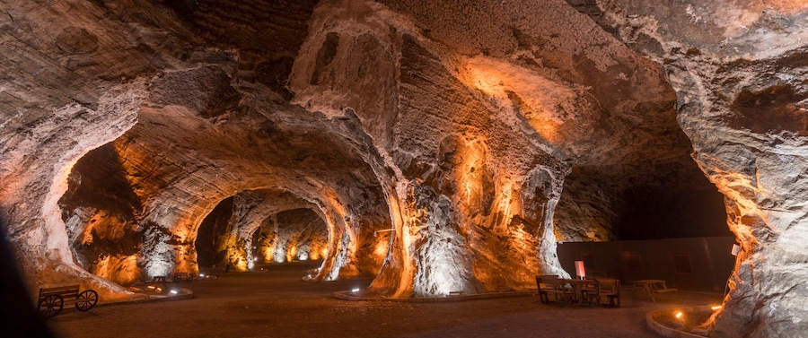 A cave with illuminated rock formations and benches.