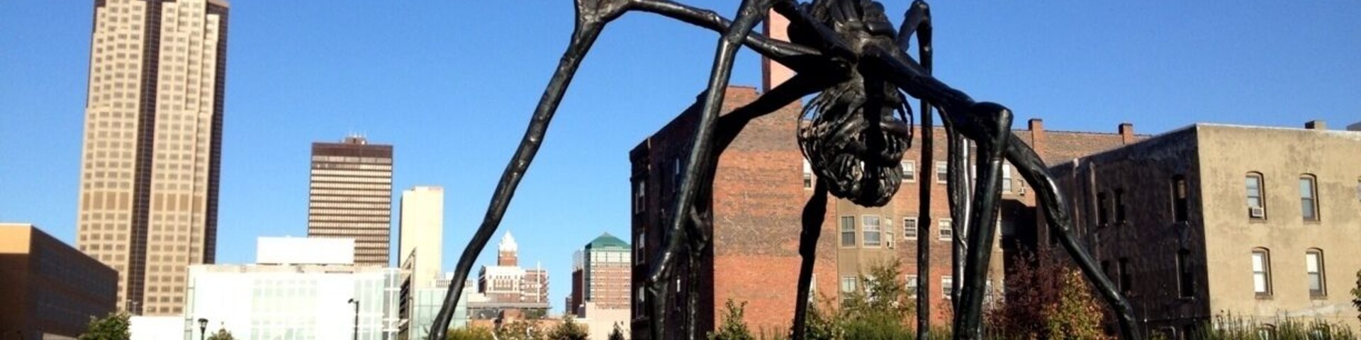 A twisted yet cool looking sculpture with the Des Moines skyline behind.