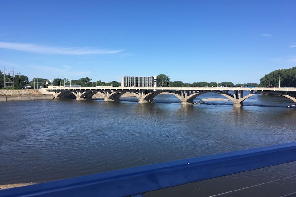 Un pont sobre un riu sota un cel blau clar.