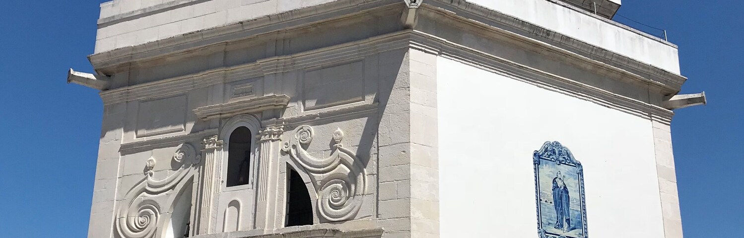 Una iglesia blanca con un campanario y una placa azul.