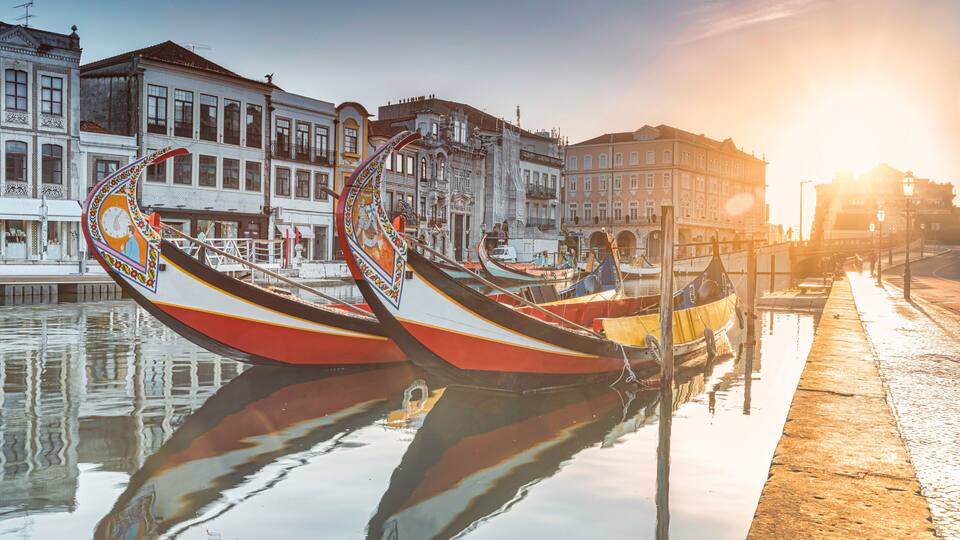 Gondolas lined up along a canal with historic buildings in the background.