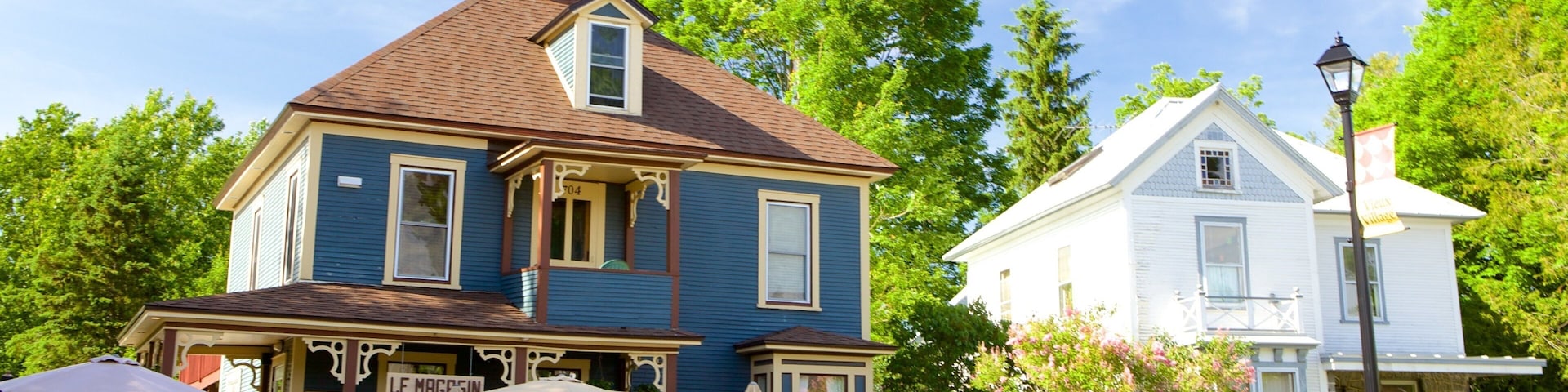 A blue house with a brown roof and a sign that says "Le Magasin Gener Restaurant".