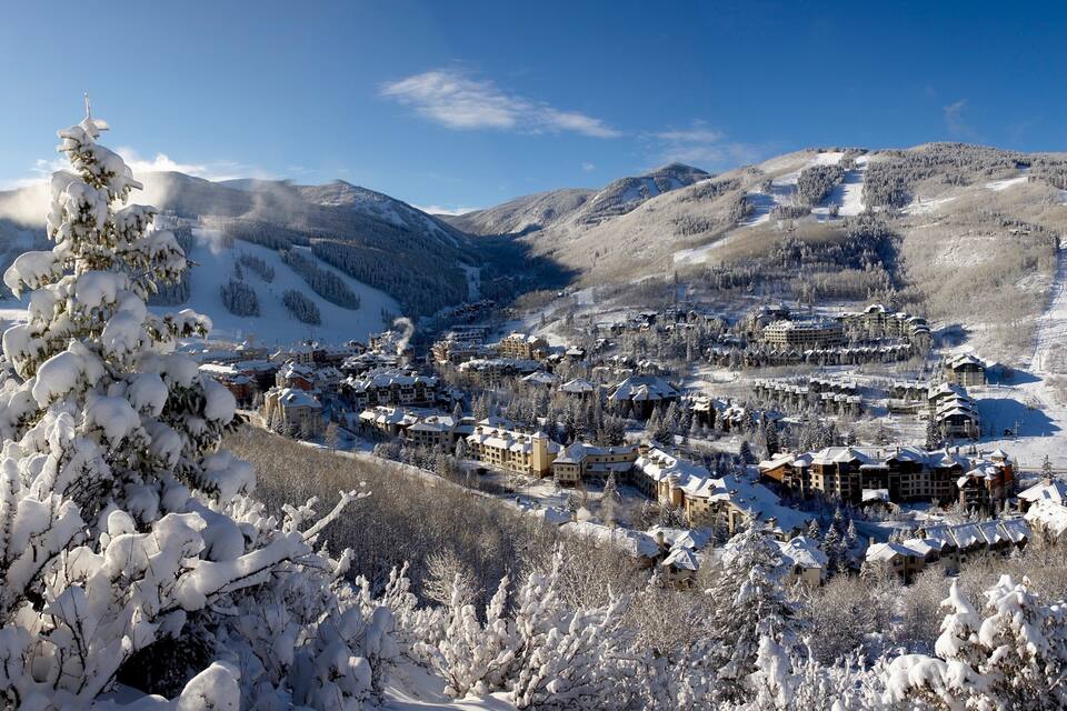 Un pueblo cubierto de nieve con pistas de esquí y edificios.