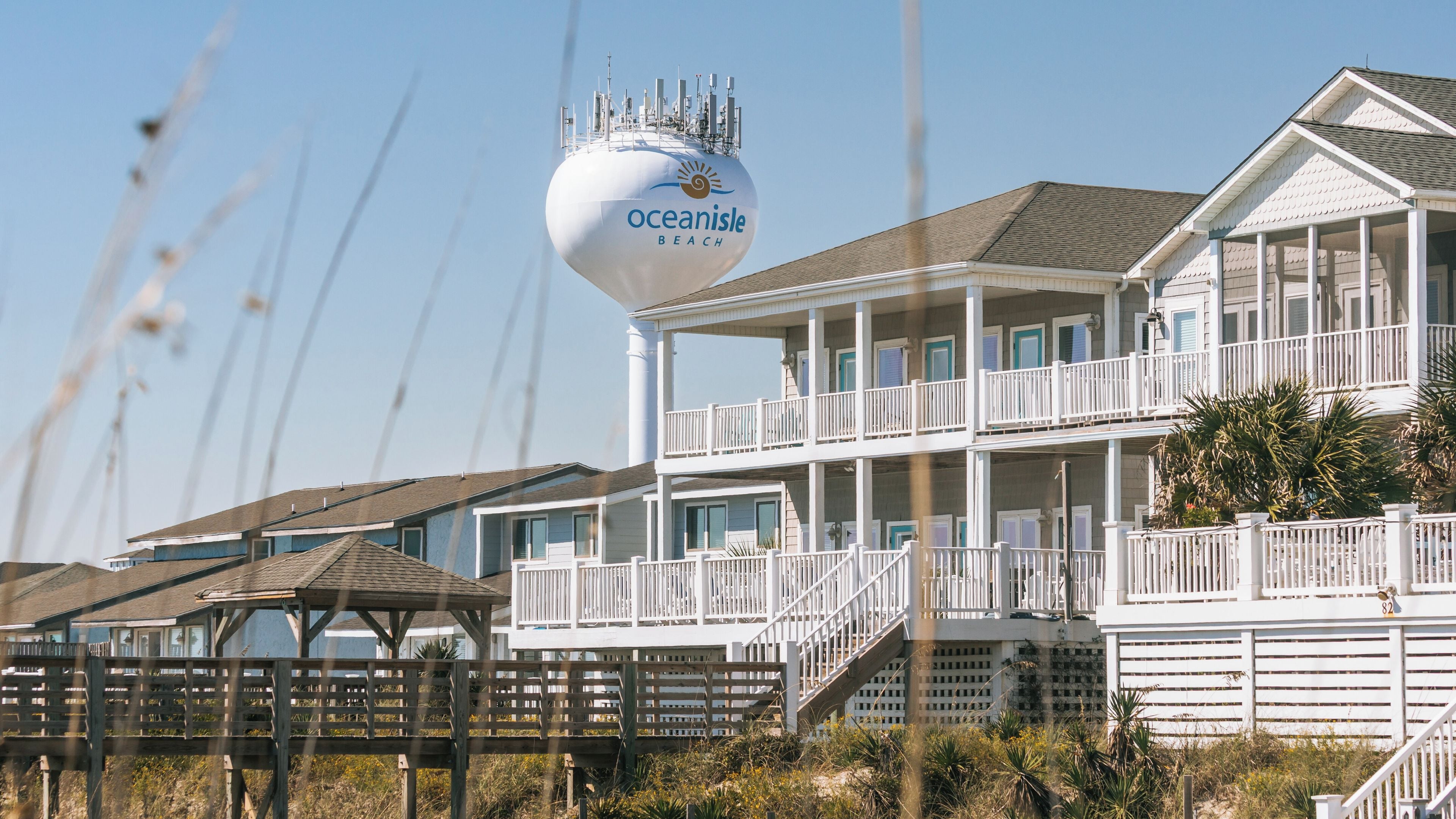 A beachfront property with a large water tank labeled 'oceanisle beach' and a multi-story building with balconies.