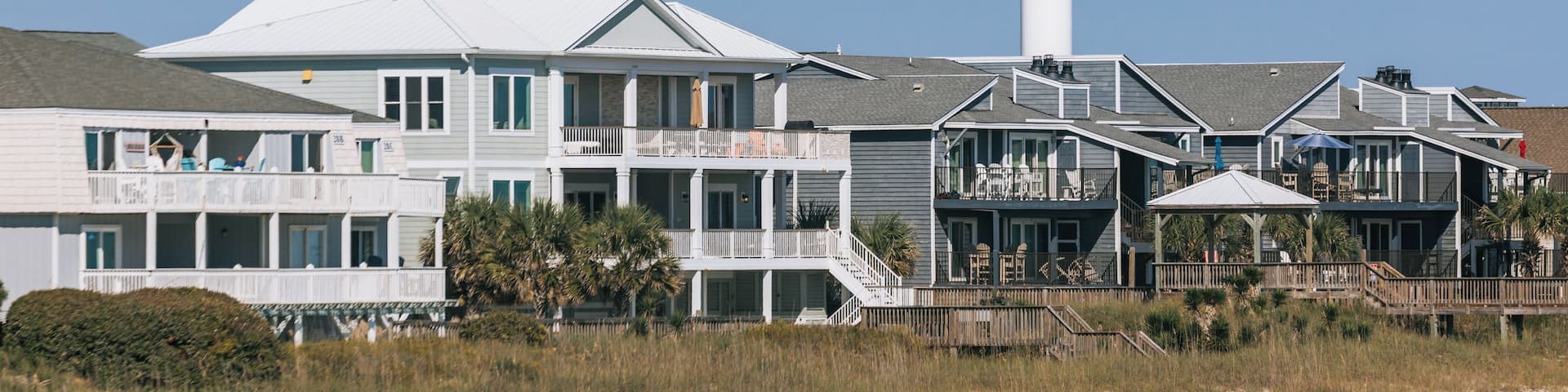 A coastal residential area with a prominent water tower labeled 'Oceanisle Beach' and a series of multi-story houses with balconies.