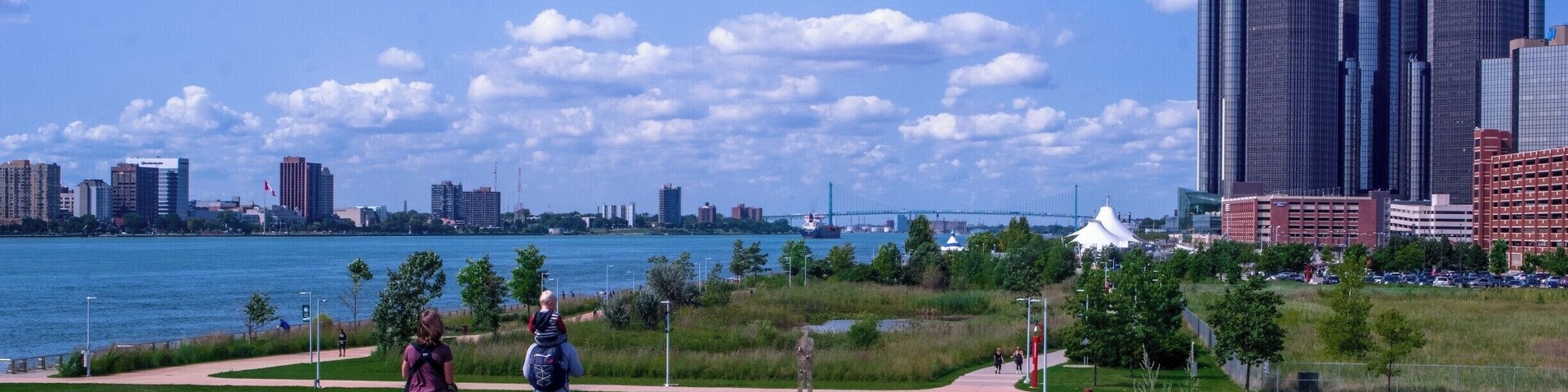 Um parque com um rio e o horizonte da cidade.