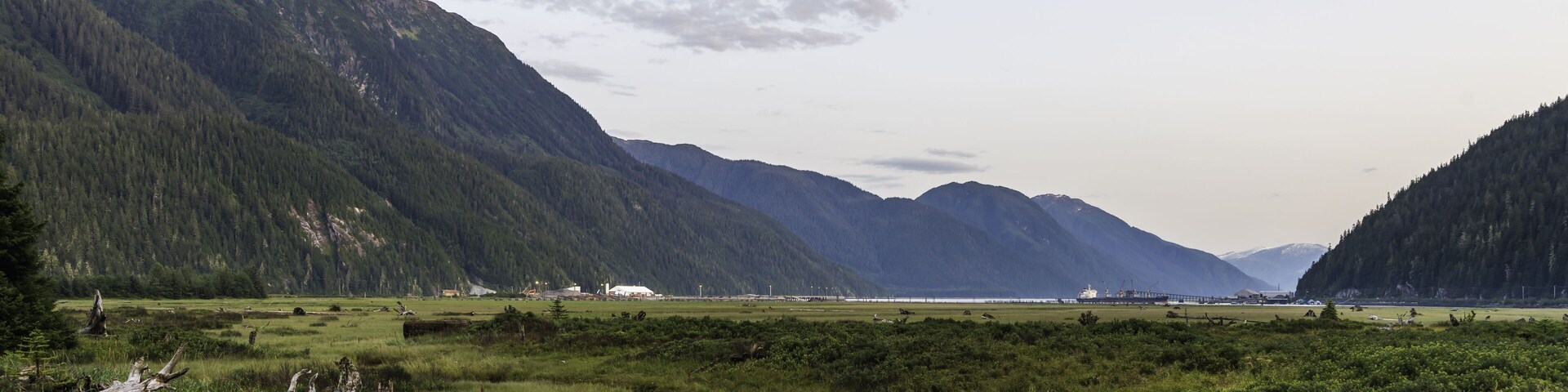 A mountainous landscape with a river and a bridge.