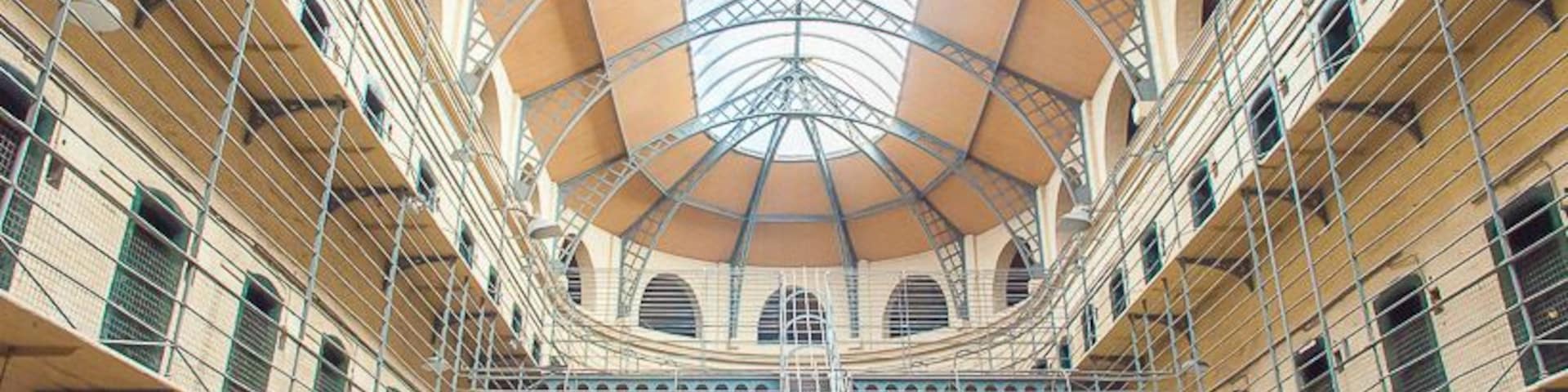 Um átrio com vários níveis, uma escadaria central e teto de vidro.