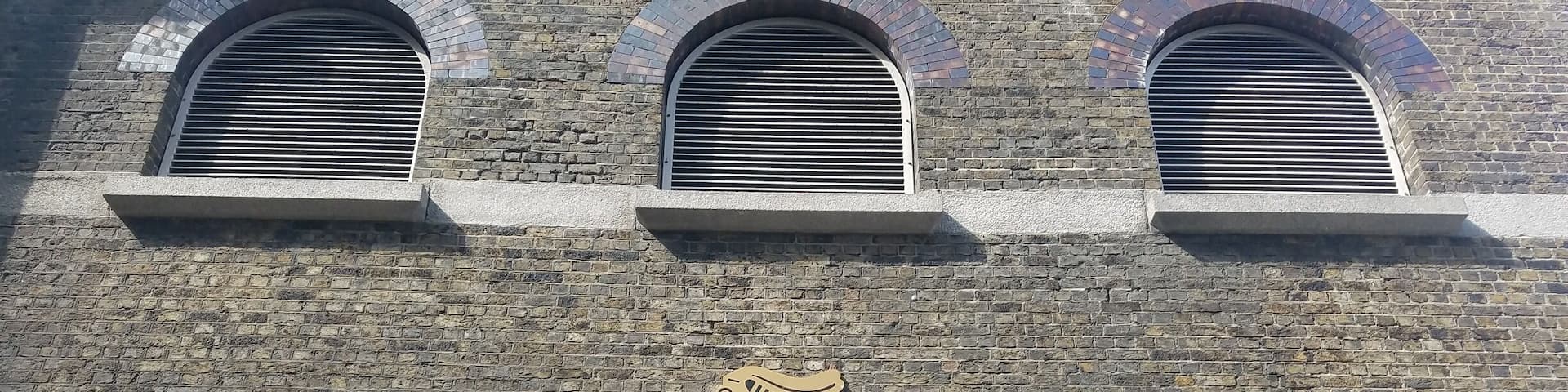 A brick building with the Guinness logo and the text "St. James's Gate Brewery Dublin".