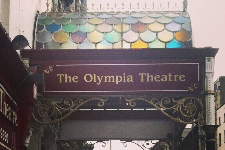 The Olympia Theatre entrance with a colorful stained glass canopy and ornate metalwork.