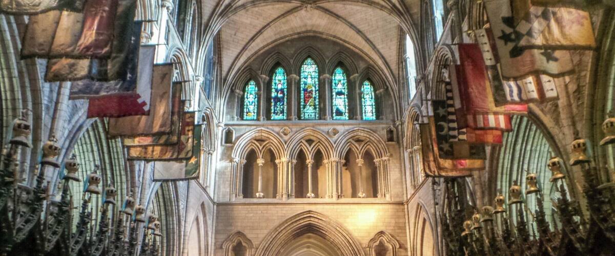 A cathedral interior with Gothic architecture, stained glass windows, and a high vaulted ceiling.