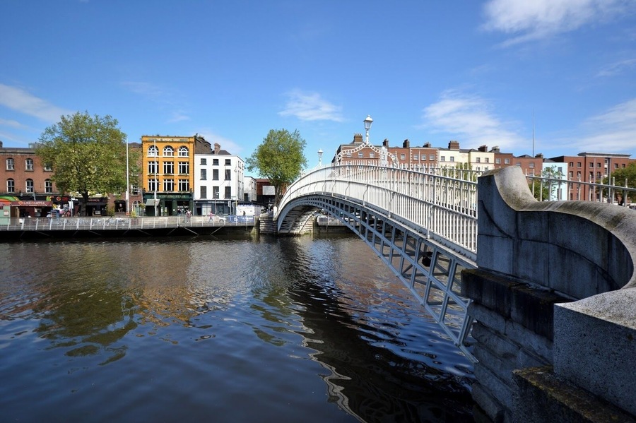 A stone bridge over a river with buildings on either side.