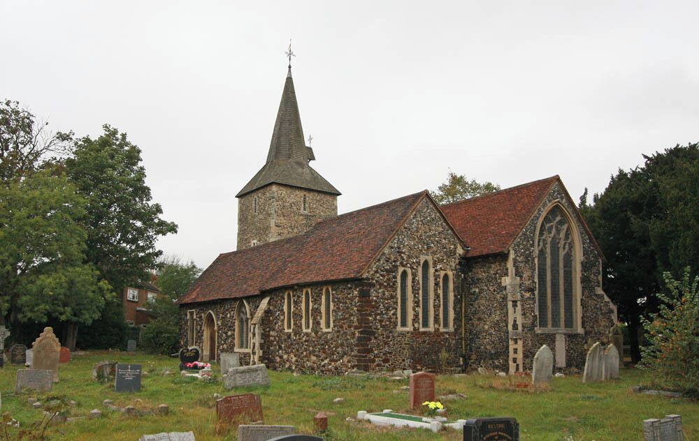 A stone church with a tall steeple and a large arched window.