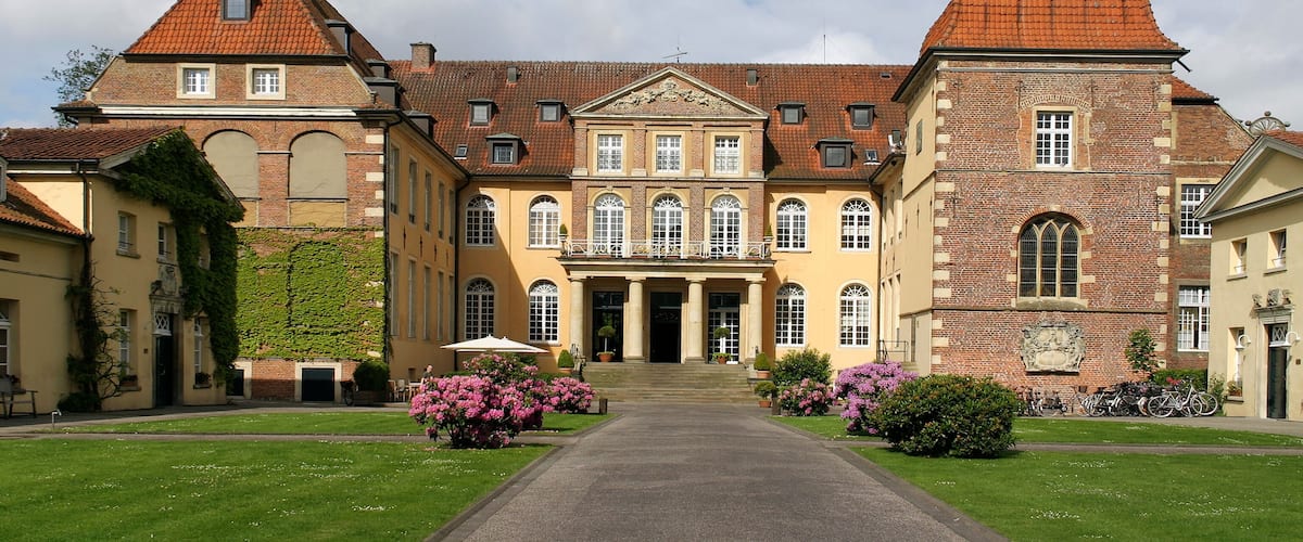 A large, historic building with a prominent tower and a central entrance.