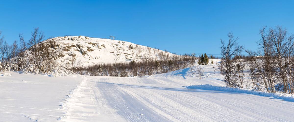 A snow-covered mountain with a clear sky.