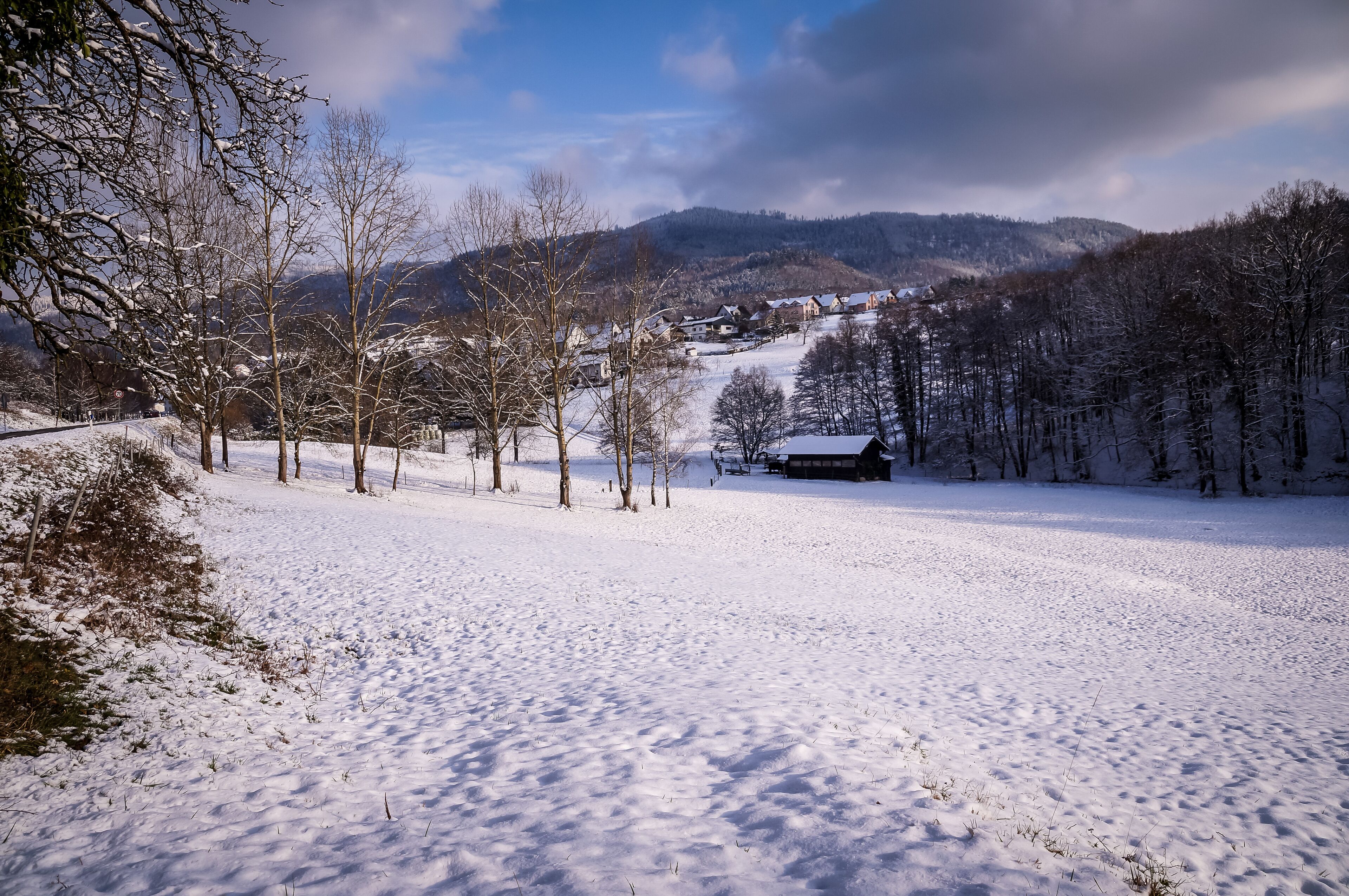 View over a farm and a little village in the Black Forest, Germany, covered in snow during winter.