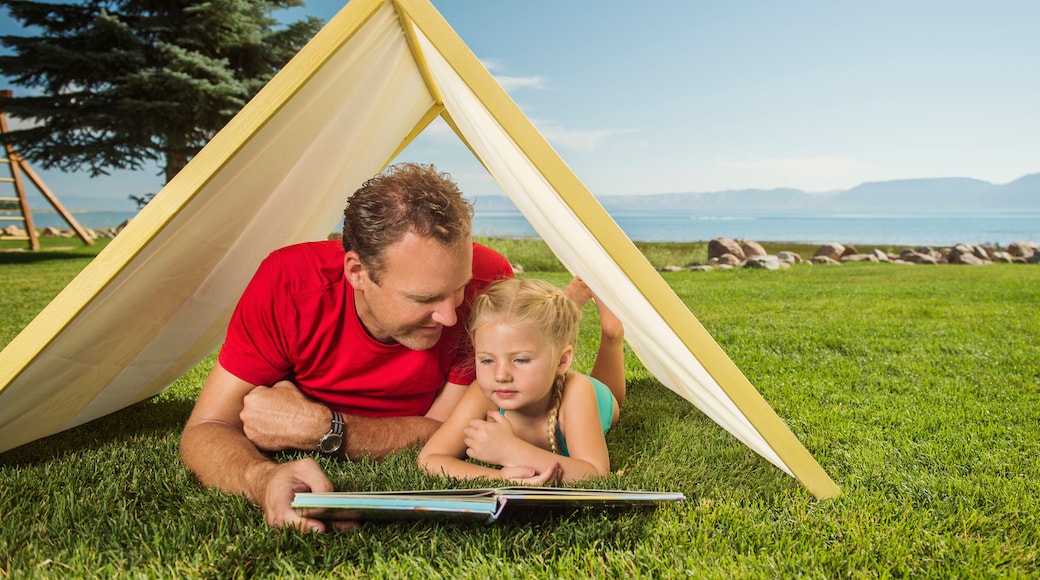 Father and daughter (2-3) playing in tent