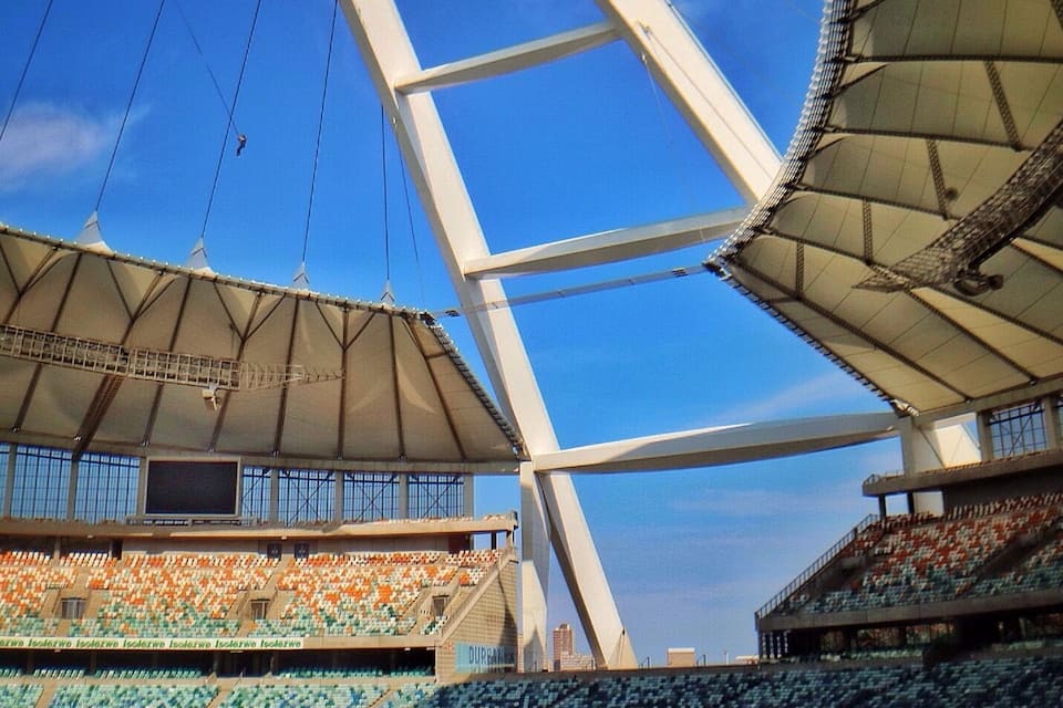 A stadium with tiered seating and a large, open roof structure.