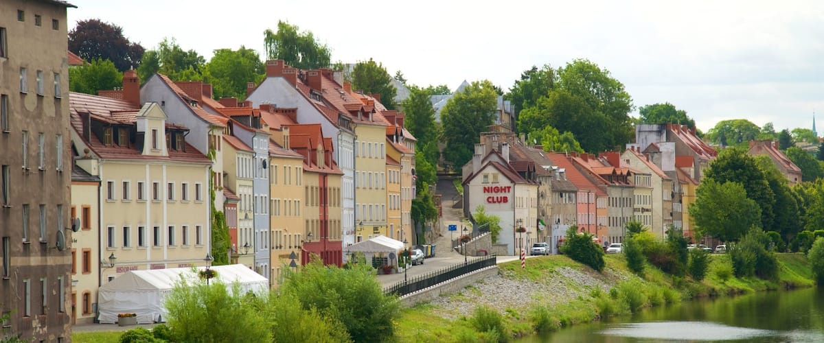 A river with buildings along the banks, a sign for 'Night Club', and a bridge in the distance.