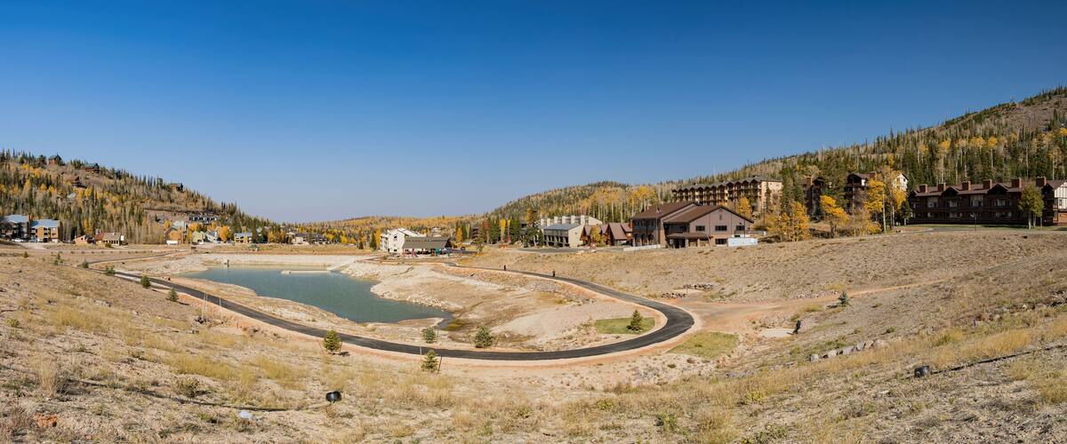 A mountainous landscape with a lake, winding roads, and residential buildings.