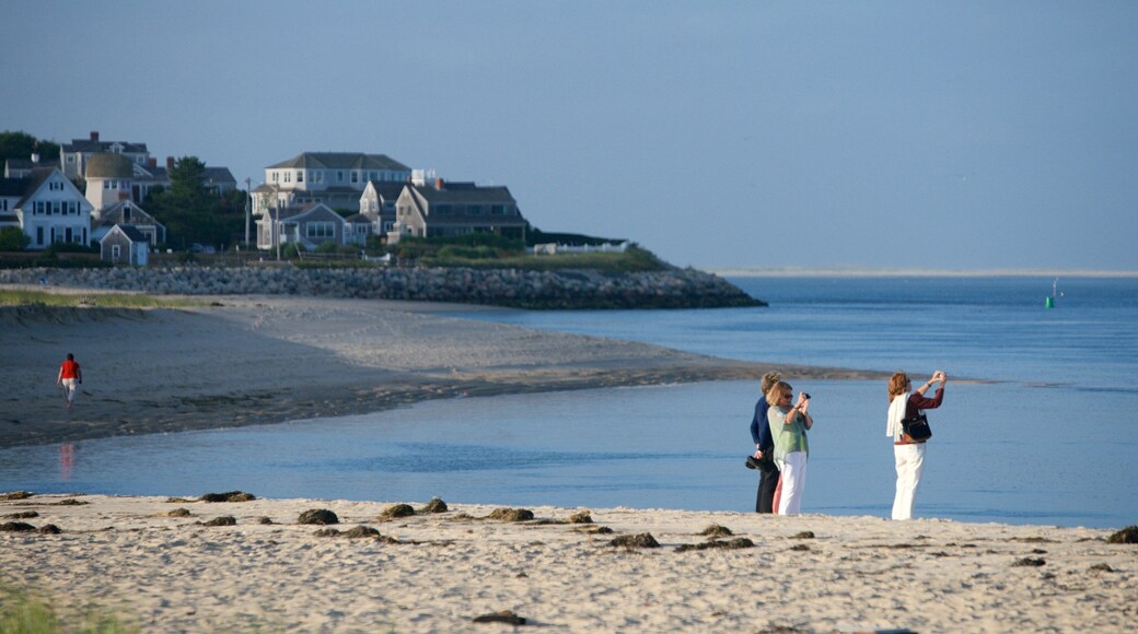 Chatham featuring a sandy beach and a house as well as a small group of people