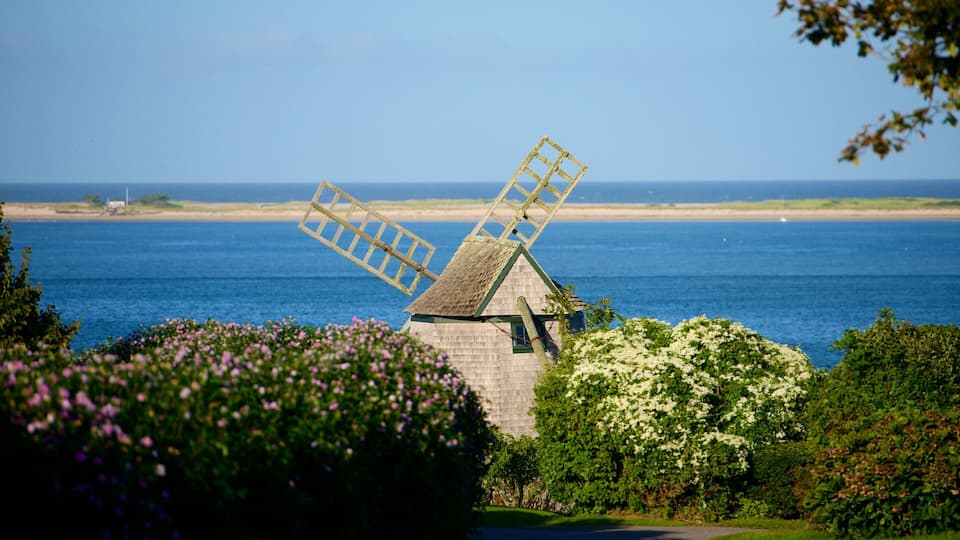 A windmill by the sea with a clear sky.