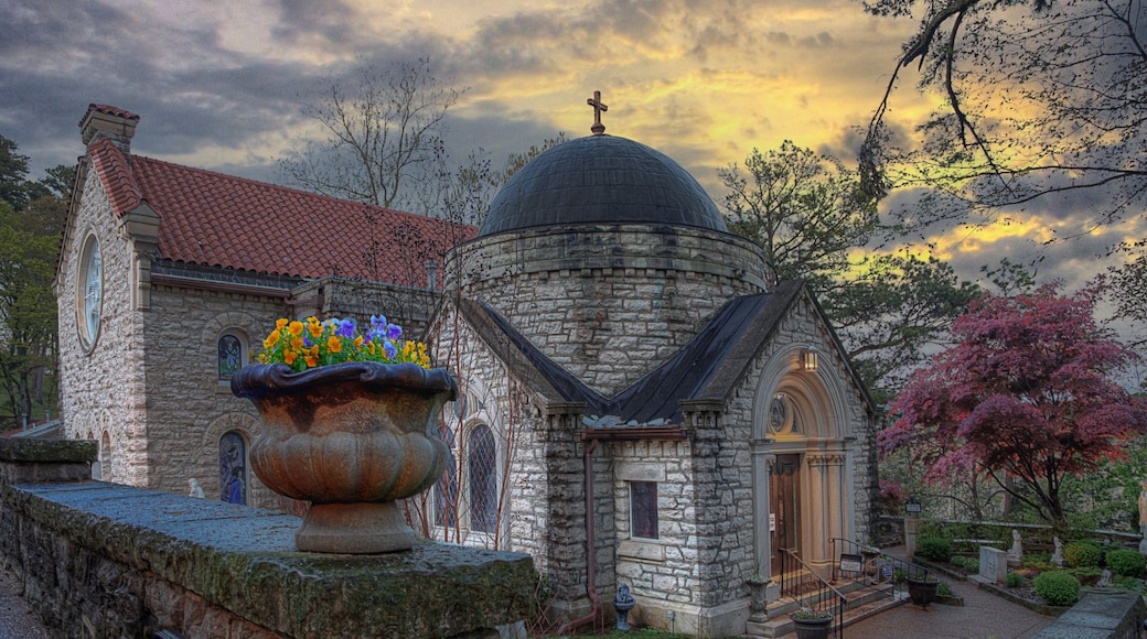 A historic church with a stone facade, a dome, and a cross on top.