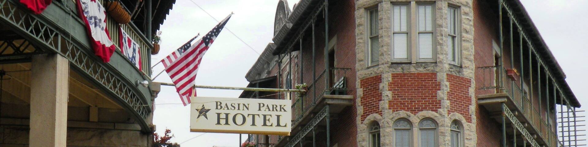 A historic building with a sign for the Basin Park Hotel.