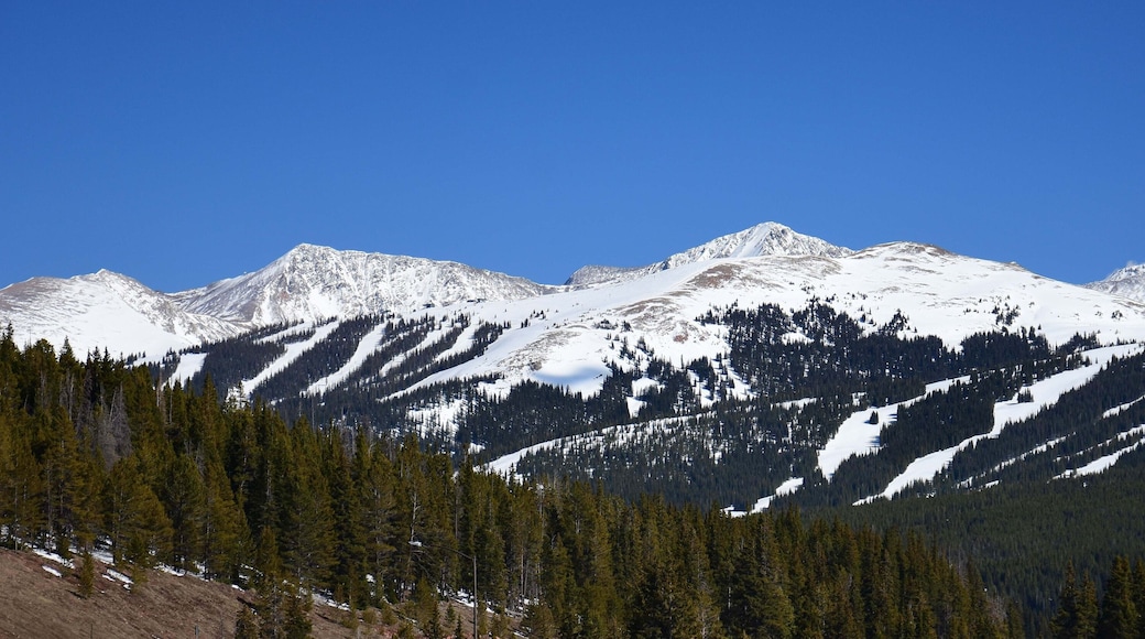 panoramic view on a sunny spring day of copper mountain ski area and snow-capped peaks from the top of vail pass, colorado