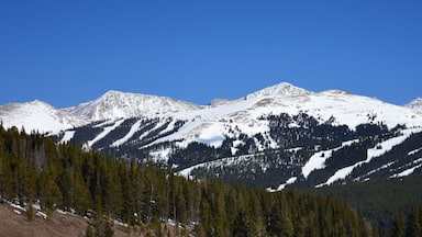 panoramic view on a sunny spring day of copper mountain ski area and snow-capped peaks from the top of vail pass, colorado
