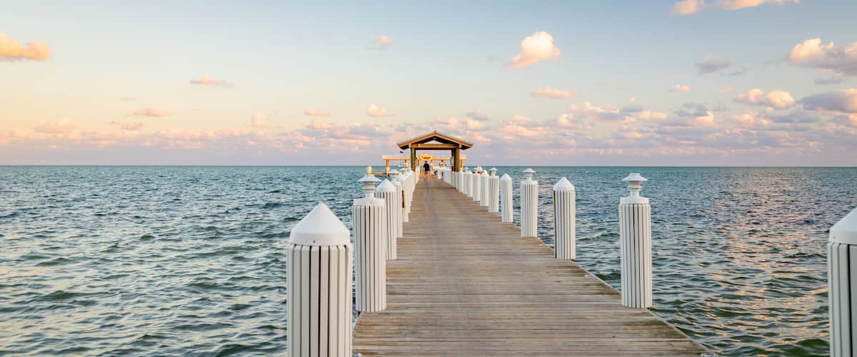 A wooden pier extending into the sea with a gazebo at the end.