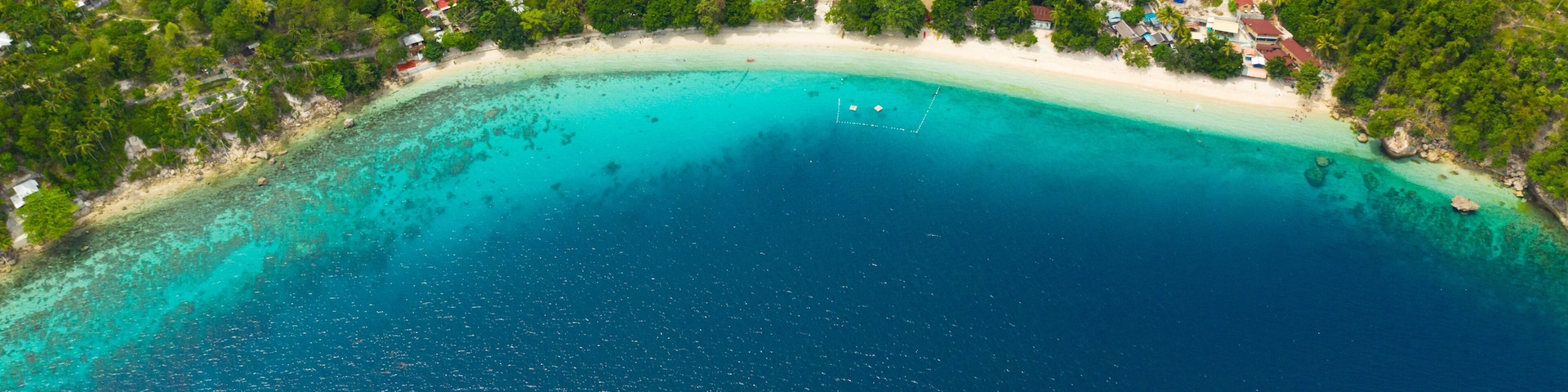 Aerial view of sandy beach on a tropical island with palm trees. Canibad beach, Philippines,Samal island.