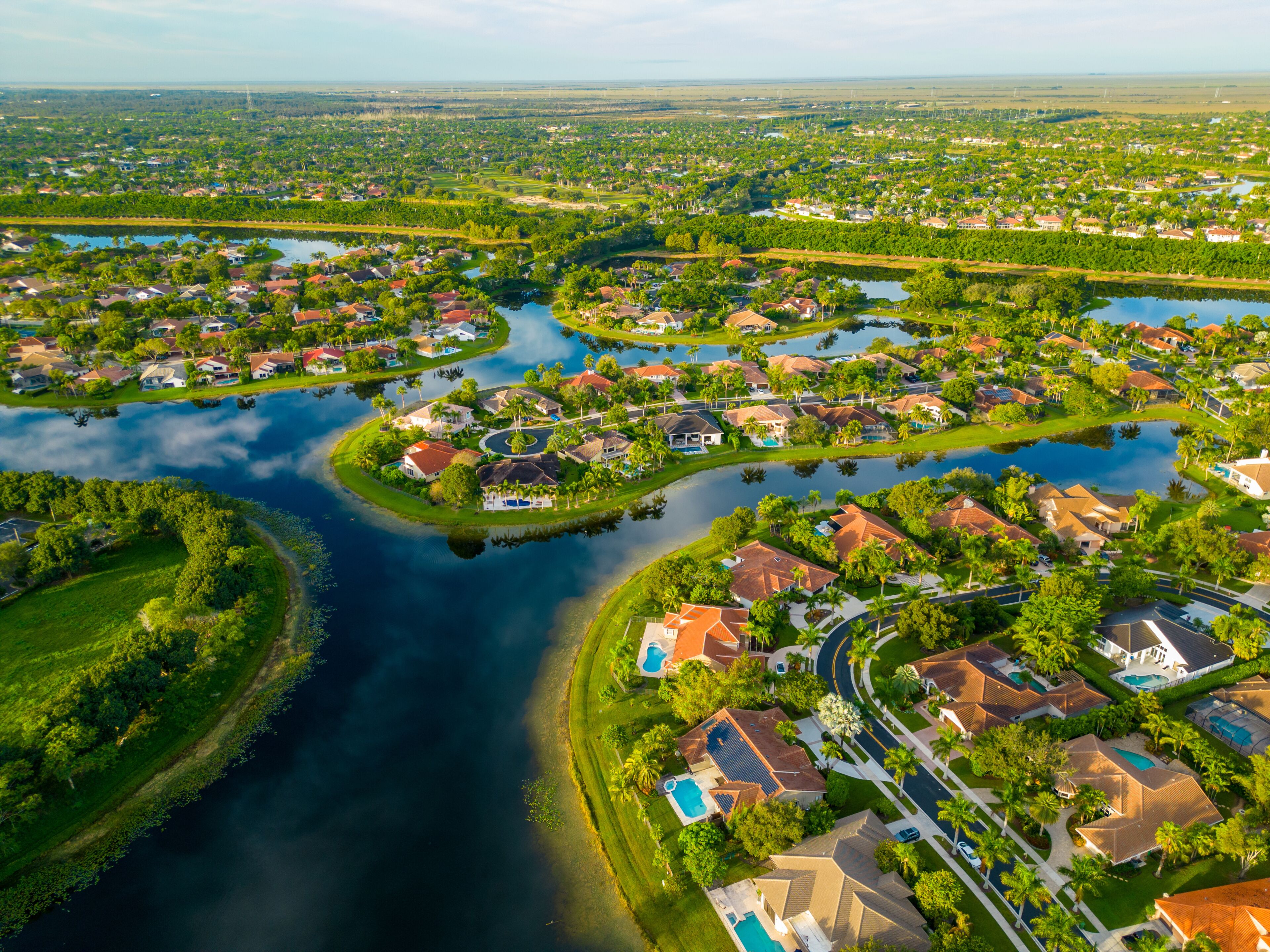 A residential area with a river, houses, and greenery.