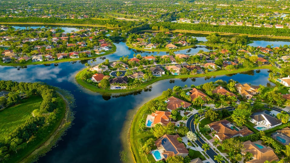 A residential area with a river, houses, and greenery.