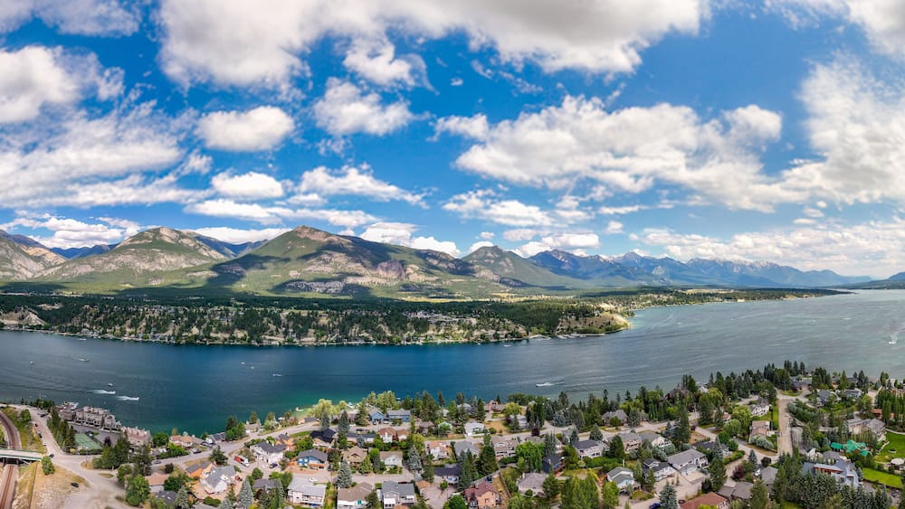 A lake surrounded by mountains and a residential area.