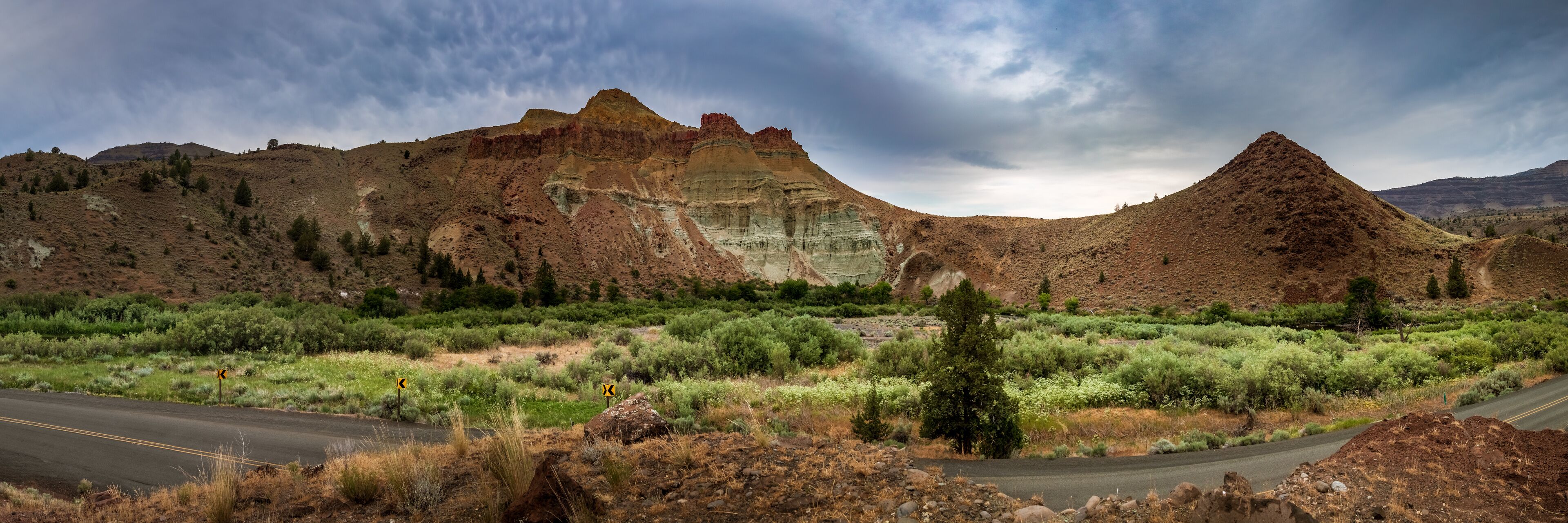 A road winding through a rugged landscape with prominent rock formations and sparse vegetation.